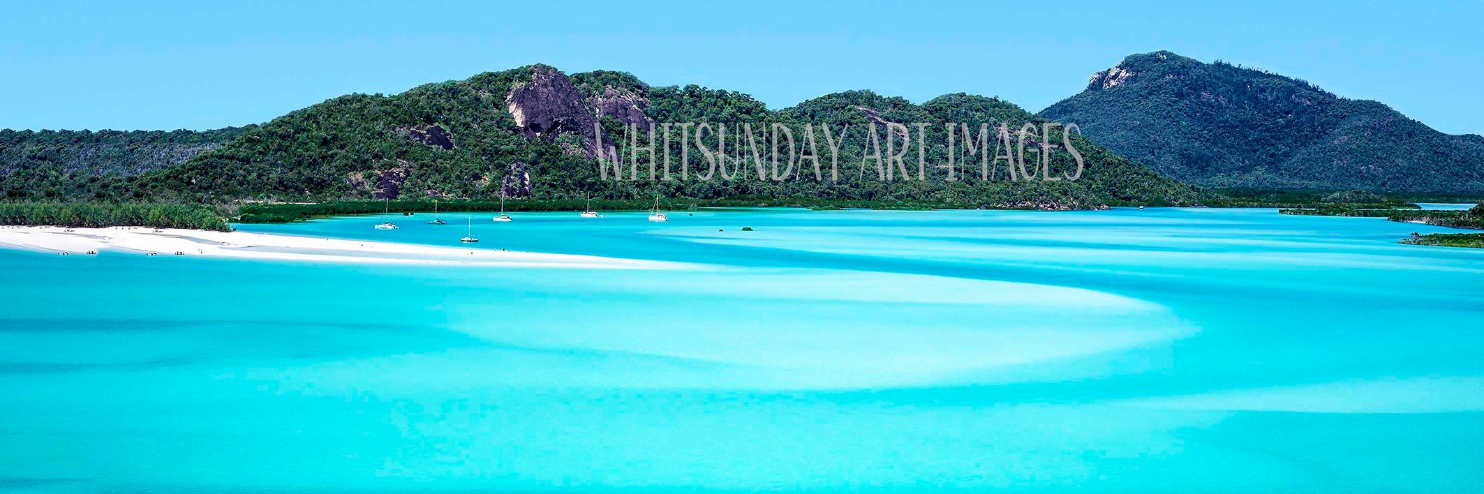 A wide panorama of Whitehaven Beach with swirling turquoise water patterns, white sand and yachts at anchor beneath forested hills.